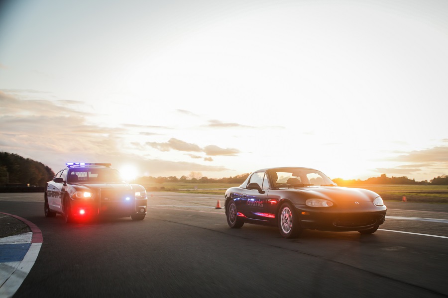 a police car chasing a Mazda MX-5