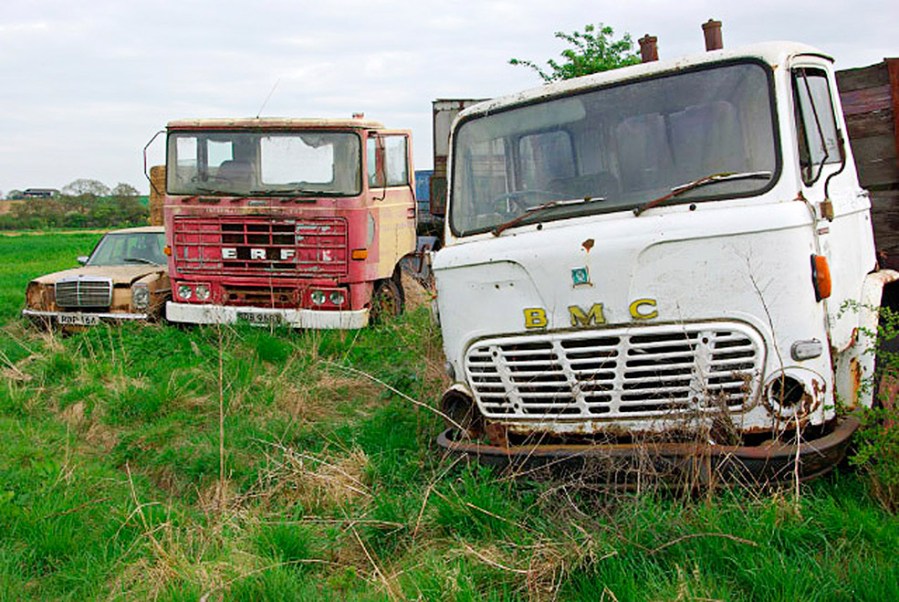 Trucks rotting in a field.