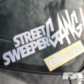 A white street sweeper sticker on a car window