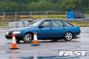 A ratty Ford Sierra drifting in the wet.