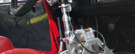 An exposed silver gear box in a red car