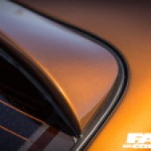 A close up of the corner of the rear window of an orange Lexus Soarer Z30
