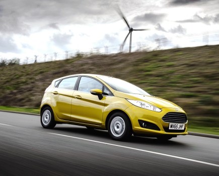 Right side driving shot of a yellow Ford Fiesta