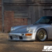 A left side shot of the front of a silver Porsche 964