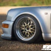 A close up of the front left gold wheel of a Porsche 964