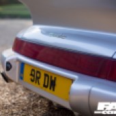 A close up of the rear license plate of a silver Porsche 964