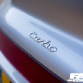 A close up of the silver turbo badge on the rear of a silver Porsche 964