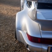 A close up of the left back corner of a silver Porsche 964