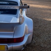 A close up of the right rear corner of a silver Porsche 964