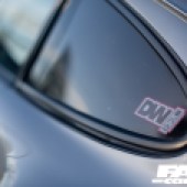 A DW sticker on the back left window of a Porsche 964