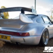 A rear right corner shot of a silver Porsche 964