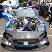 A woman climbing into a blue and black Mazda RX7 at the Forge Action Day 2019