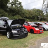 A row of black silver and red cars next to the base of a telephone tower at the Forge Action Day 2019