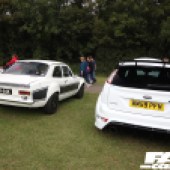 Rear shot of a black and white Ford Escort next to a white Ford Focus RS