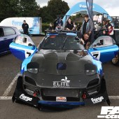 Central front view of a black and blue Mazda RX 7 with the doors open at the Forge Action Day 2019