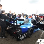 Rear right side shot of a black and blue Mazda RX 7 with the door open at the Forge Action Day 2019