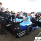 People standing around the left side of a blue and black Mazda RX 7 at the Forge Action Day 2019