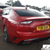 Rear view of the left side of a red Kia Stinger GT S at the Forge Action Day 2019