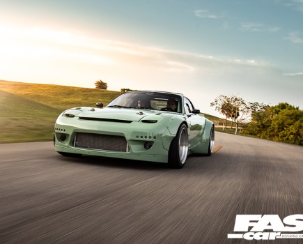 A front shot of a mint green Mazda RX 7 driving