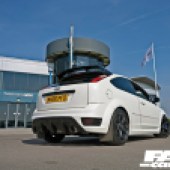 Low rear right view of a white AWD Focus ST parked outside