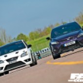 Frontal view of a white and a purple AWD Focus ST cars driving side by side