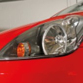 The front left headlight of a red Ford Fiesta ST Mk6