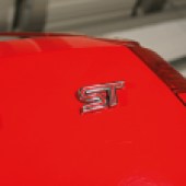 A silver ST badge on the outside of a red Ford Fiesta ST Mk6