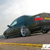 A low rear left side shot of a black BMW 3 Series E46