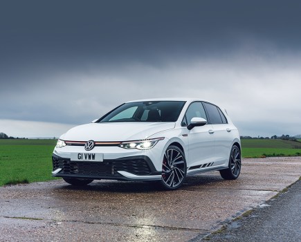 Front left shot of a stationary, white VW Golf GTI Clubsport Mk8 with dark clouds behind