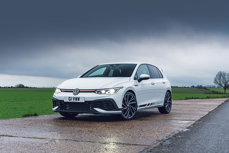 Front left shot of a stationary, white VW Golf GTI Clubsport Mk8 with dark clouds behind