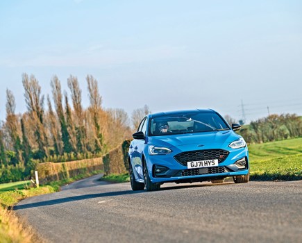 Bright blue Ford Focus ST Edition approaching on sunny countryside road