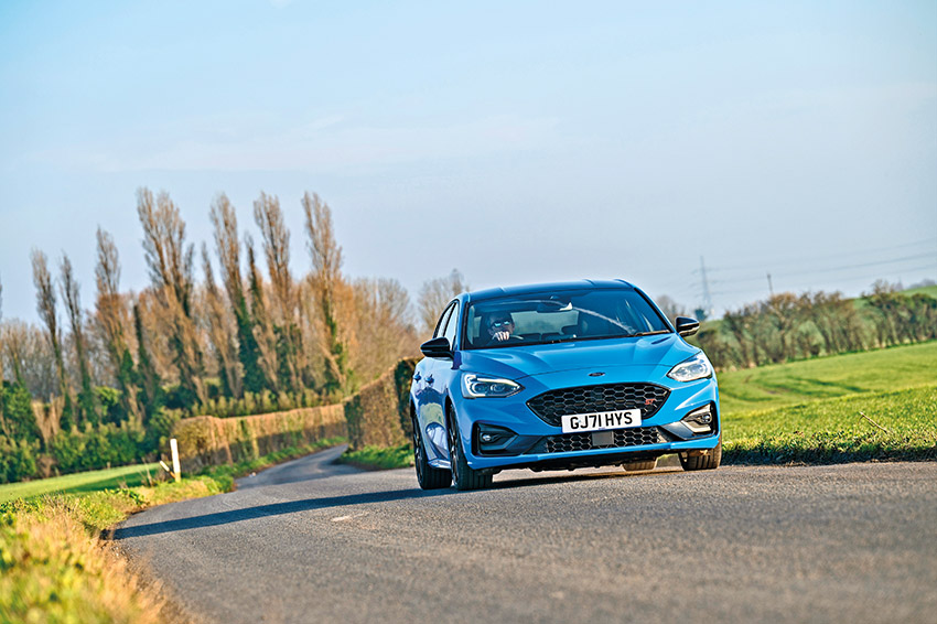 Bright blue Ford Focus ST Edition approaching on sunny countryside road