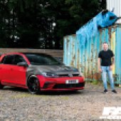 A man in a black t-shirt and jeans stood next to a black and red tuned VW Golf GTI Mk7