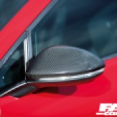 A close up of the left wing mirror of a black and red tuned VW Golf GTI Mk7