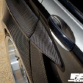 A close up shot of the right rear door handle of a dark grey BMW series 7