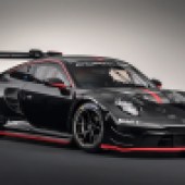 front left shot of a stationary black Porsche 911 GT3 R in a showroom