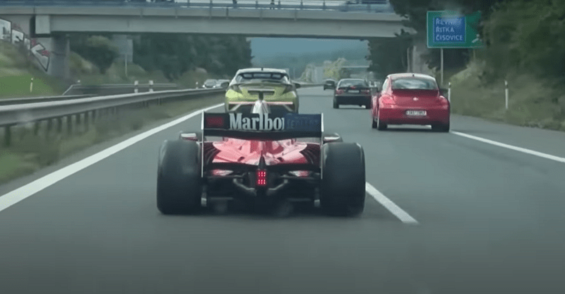 A Dallara GP2 car being driven on the motorway.