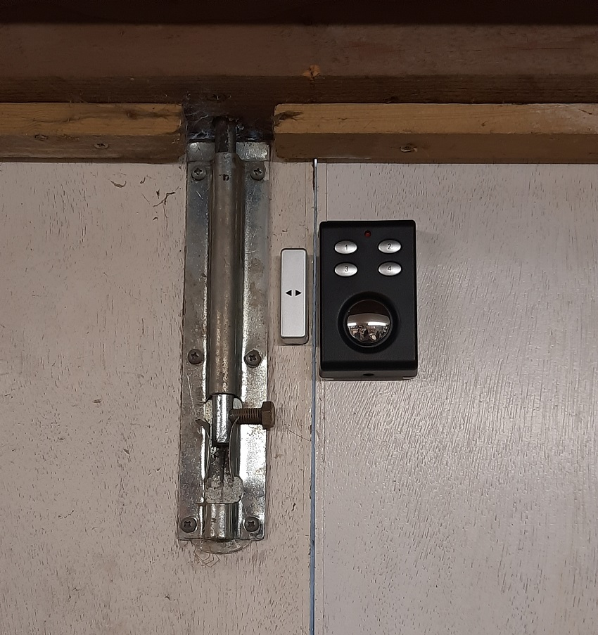 Defender's new garage alarm positioned on a workshop door