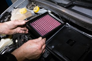 A Performance air filter being installed into a car.