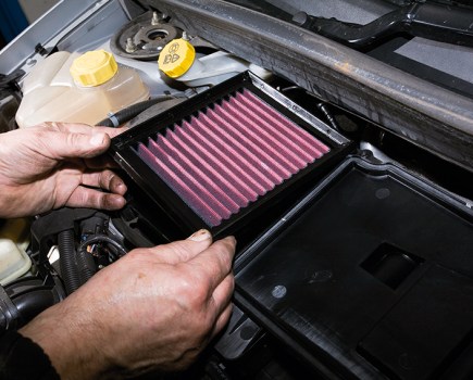 A Performance air filter being installed into a car.
