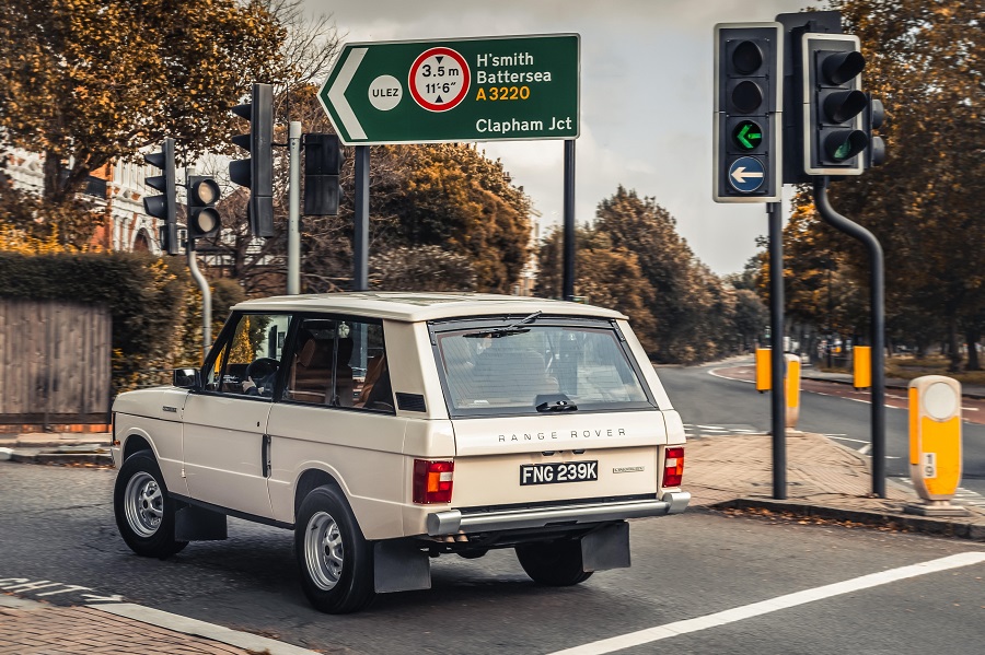 A classic Range Rover passing by a ULEZ sign.