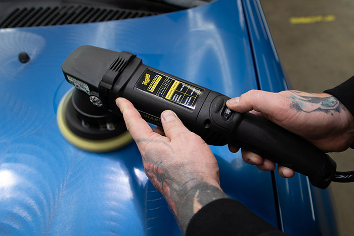 adjusting the speed on a polisher during paint correction process 