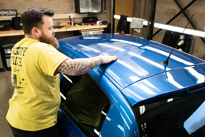 Using an applicator in circles on the roof of a clio