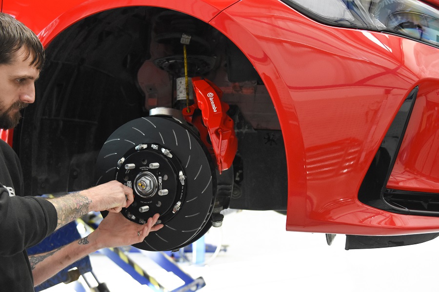A man installing an EBC brake rotor onto an FL5 Civic. 
