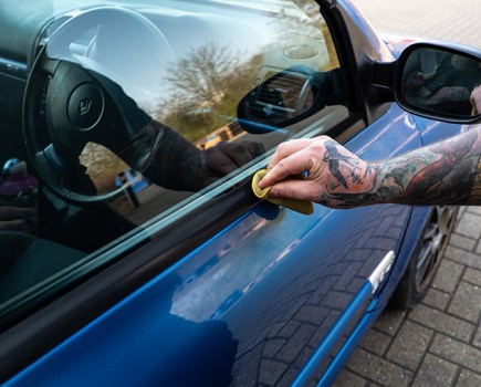 Using an applicator to restore black trim on a car