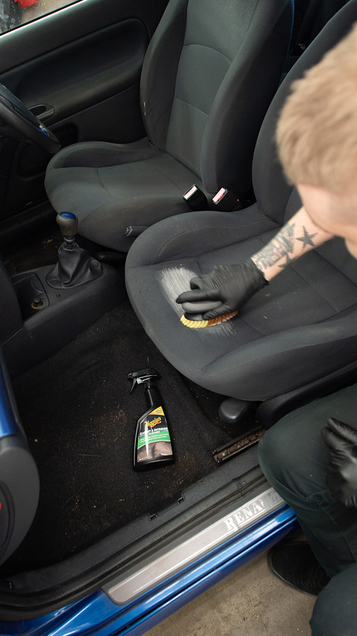 Scrubbing cleaner on the seats during car interior clean