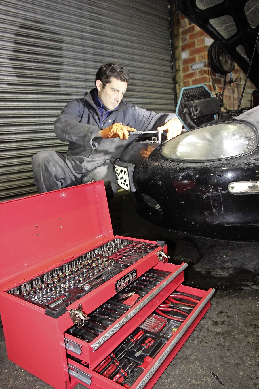 A mechanic using a Clarke tool kit.