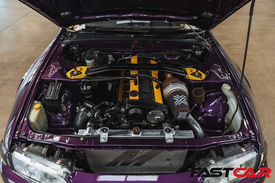 An RB25 sits in the Skyline's engine bay.