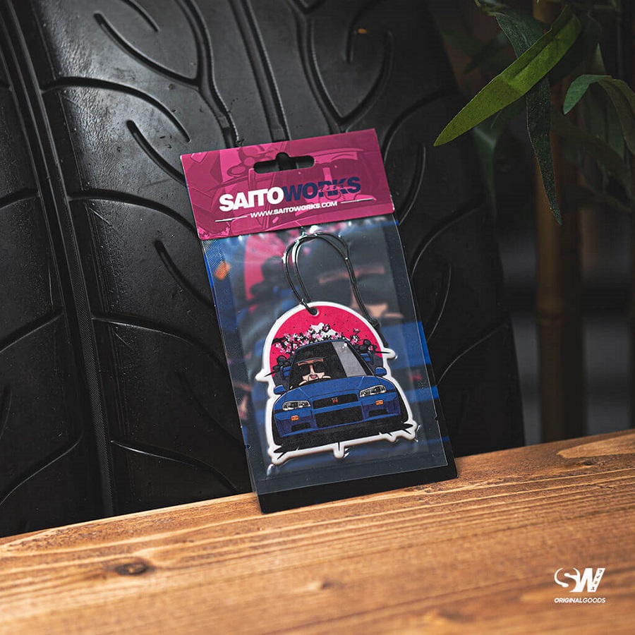 A Saitoworks air freshener propped up against a tire.