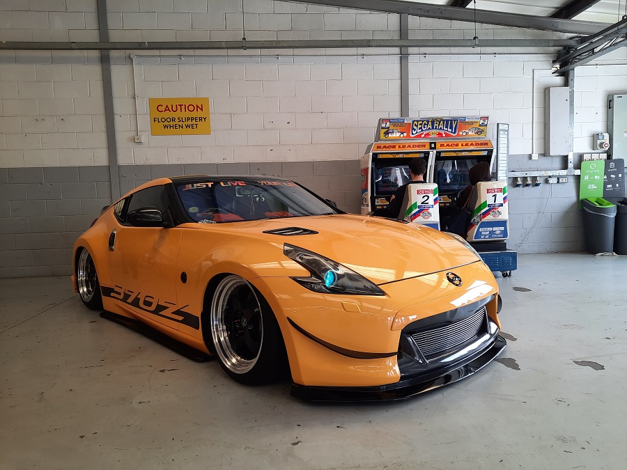 A yellow Nissan 370z in a pit garage.